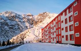 A picture of the outside of a hotel in the mountains with snow